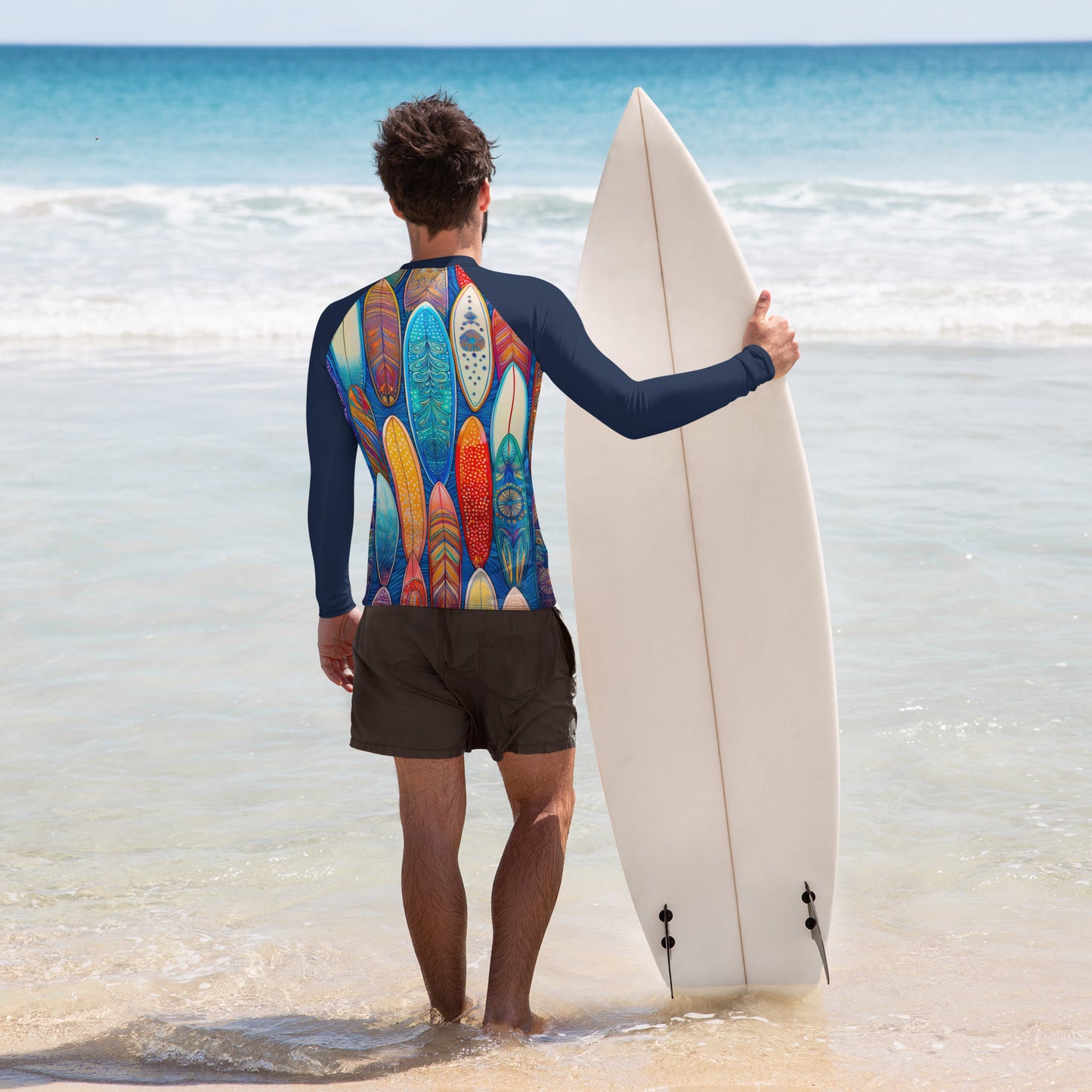 Man in a colorful surfboard-patterned rash guard walking toward the ocean with a surfboard. Perfect for sun protection and style.